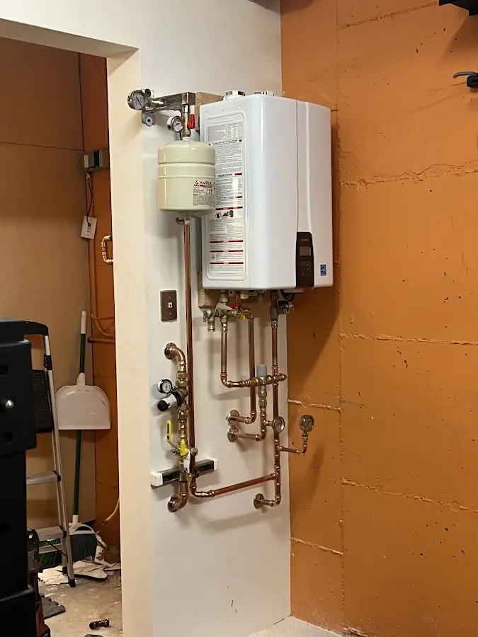 Plumbing technician inspecting water heater connections in Wildwood Lake